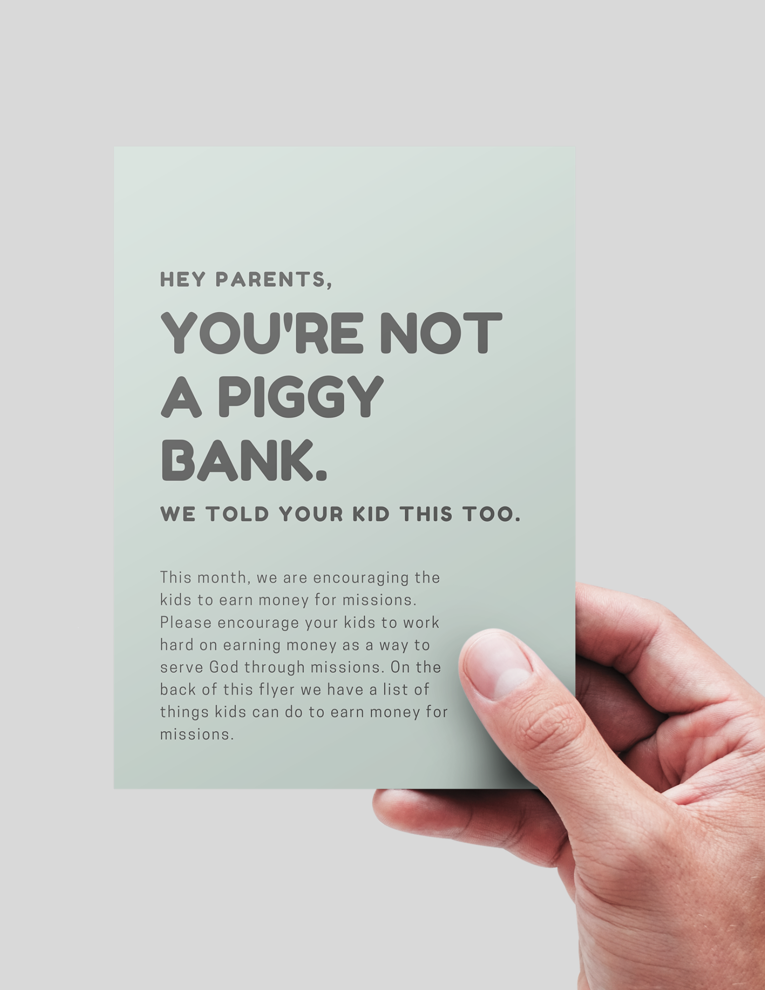 Hand holding a flyer with text about parents not being piggy banks and encouraging children to earn money for missions.